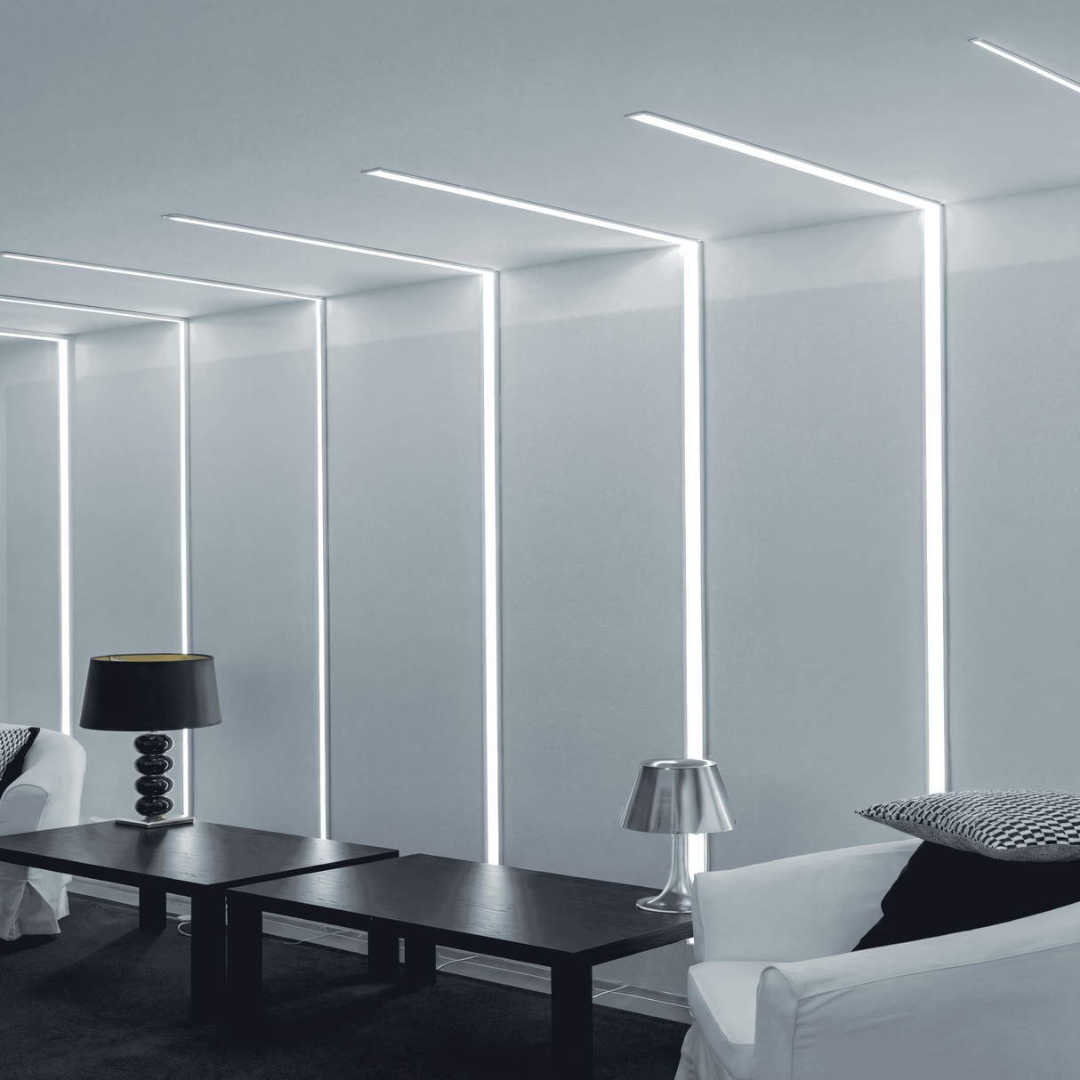 Líneas de luz LED empotradas en paredes blancas para señalética y diseño de oficinas.