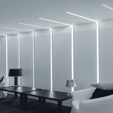 Líneas de luz LED empotradas en paredes blancas para señalética y diseño de oficinas.