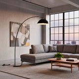 Diseño lumínico perimetral mediante lámpara de arco en un espacio de concepto abierto tipo loft urbano.