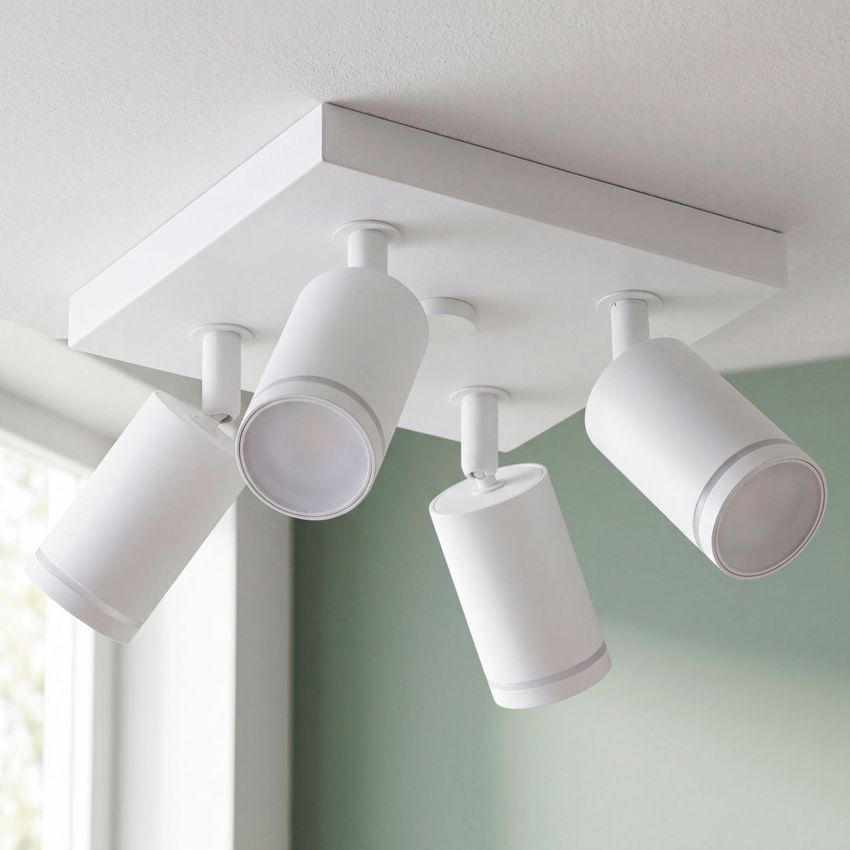 Plafón de sobreponer con cuatro focos direccionables en blanco mate para proyectos de arquitectura contemporánea.