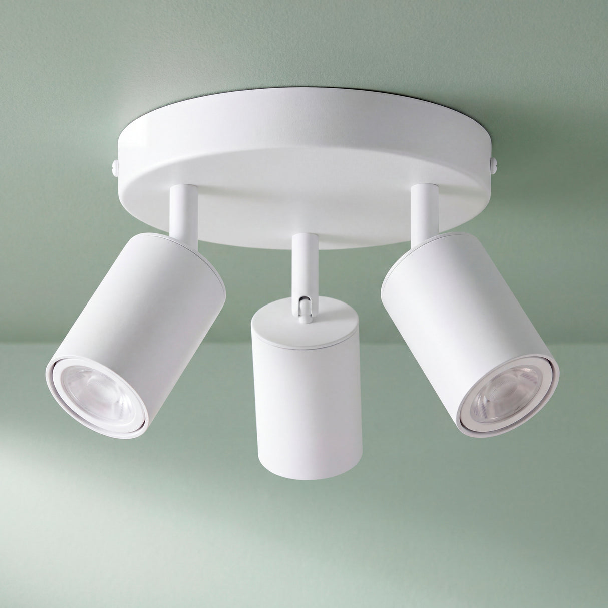 Plafón circular de tres focos orientables en blanco mate para proyectos de arquitectura contemporánea.