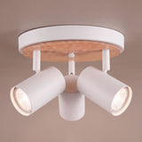 Plafón circular de sobreponer con tres focos orientables y disco decorativo en madera natural sobre techo claro.
