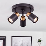 Plafón circular de tres focos orientables en negro mate con acento dorado para arquitectura contemporánea.