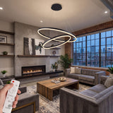 Lámpara colgante de tres aros negros en salón contemporáneo con techos altos y diseño industrial.