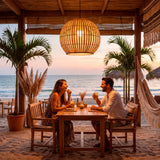 Pareja cenando en terraza de playa bajo la luz cálida de la lámpara Betania.