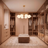 Lámpara Victoria Gold aportando elegancia en el centro de un gran vestidor residencial.