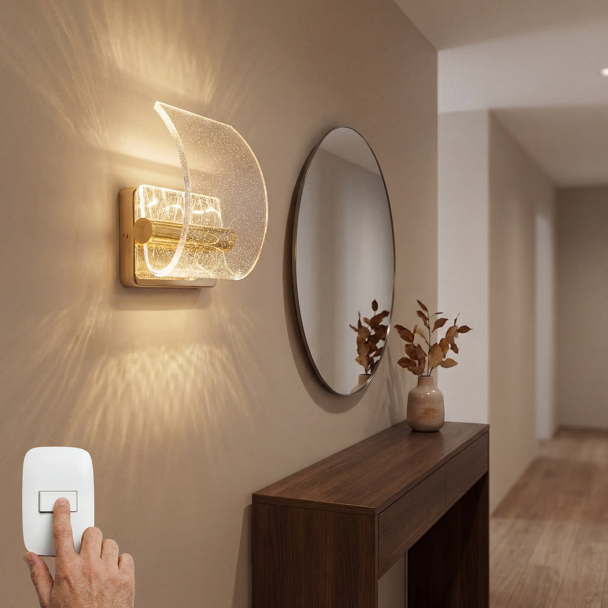 Lámpara de pared Wave Gold sobre una consola de madera en recibidor.