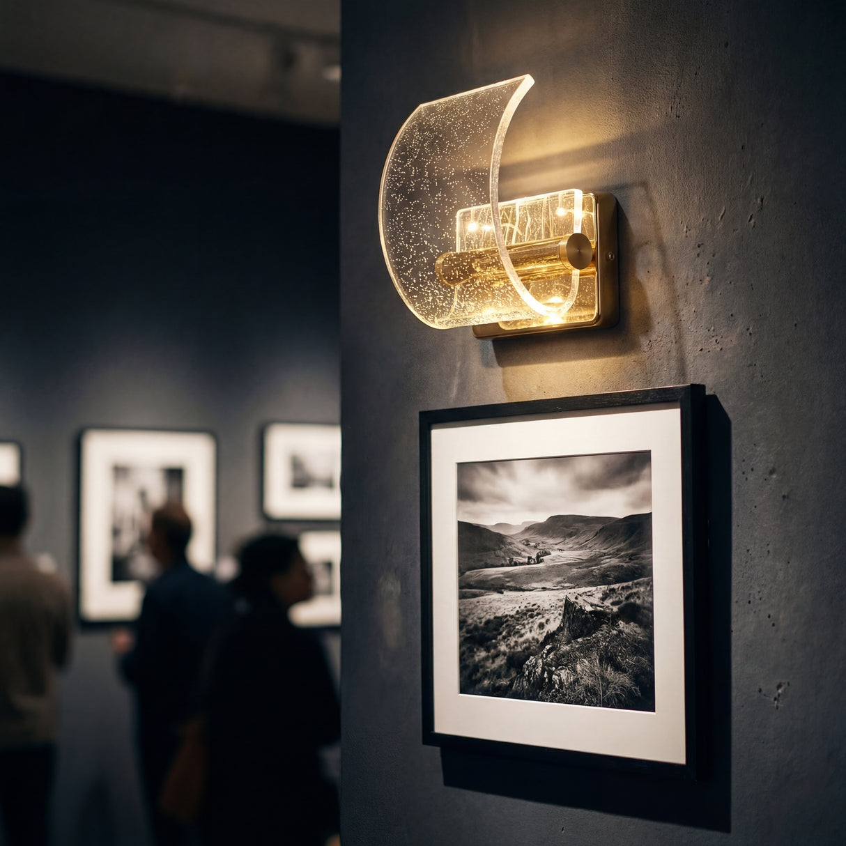 Lámpara Wave Gold utilizada para iluminar cuadros en una galería de arte.