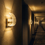 Pasillo largo de hotel iluminado con varios apliques de pared Wave Gold.