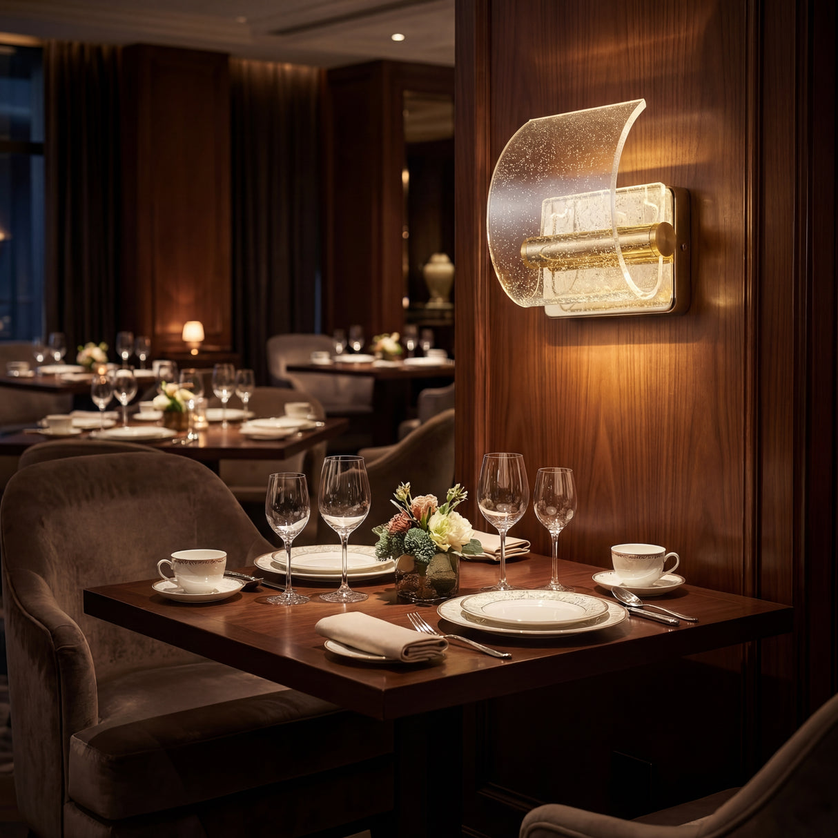 Apliques Wave Gold creando ambiente elegante en mesa de restaurante.