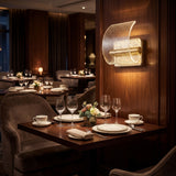 Apliques Wave Gold creando ambiente elegante en mesa de restaurante.