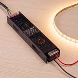 Driver slim conectado a tira LED flexible emitiendo luz cálida para interiorismo residencial premium.