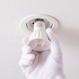 Técnico instalando un foco empotrable para aportar eficiencia lumínica y confort óptico residencial.