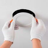 Proceso de instalación de spot Downlight LED circular con resortes de sujeción naranja.