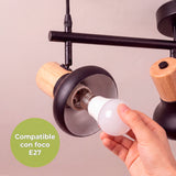 Proceso técnico de colocación de lámpara E27 en pantalla orientable con detalles en madera natural.