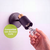 Colocación manual de bombilla dicroica orientable en la luminaria de sobreponer con acabado mate.