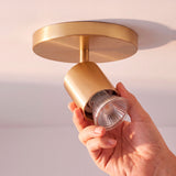 Proceso de mantenimiento e instalación técnica de bombilla dicroica en reflector cilíndrico.