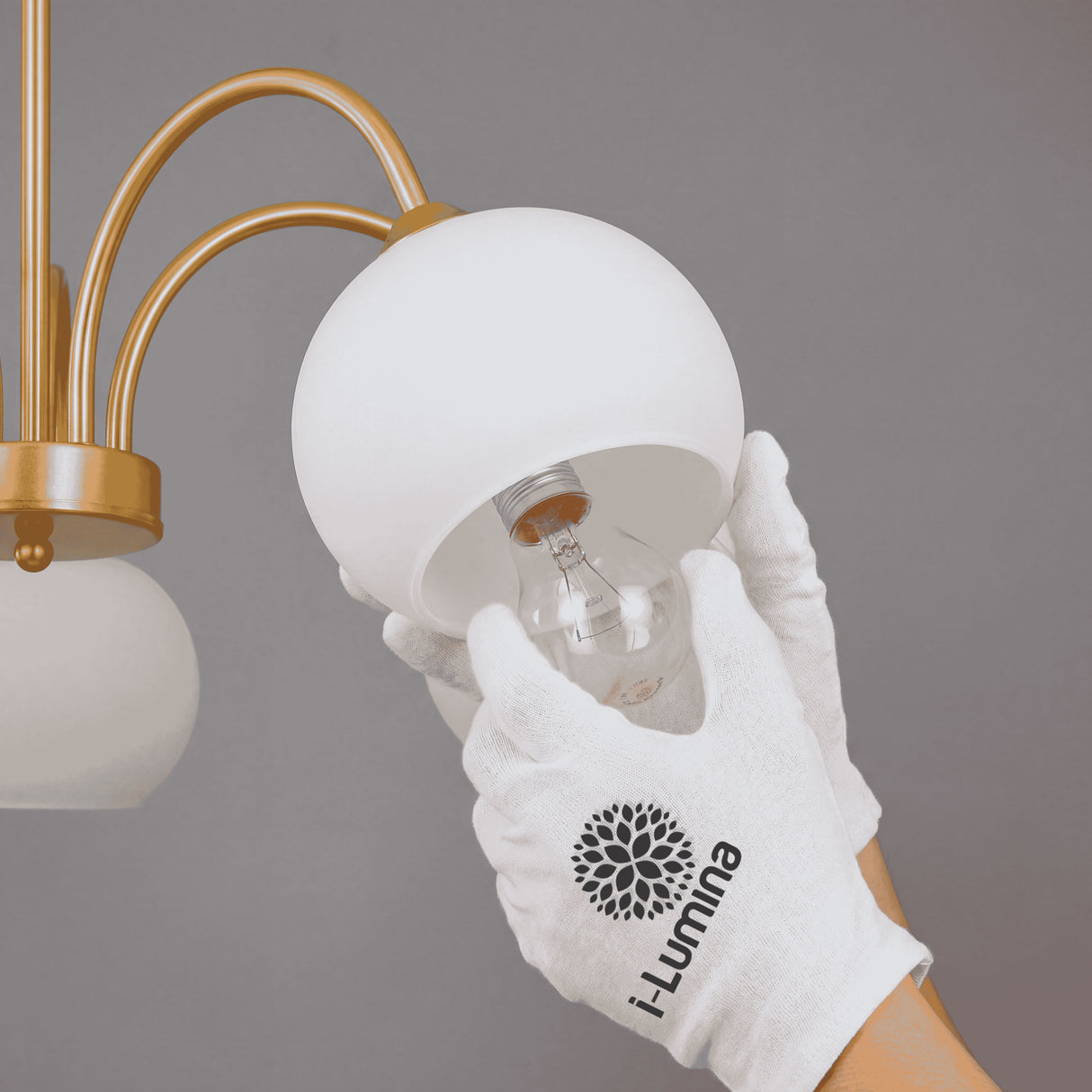 Técnico instalando una bombilla en el interior de la tulipa de vidrio con guantes de protección.