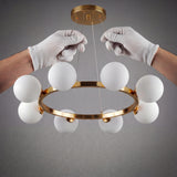 Manos profesionales instalando la lampara Collier Gold asegurando el soporte del dosel dorado al techo.