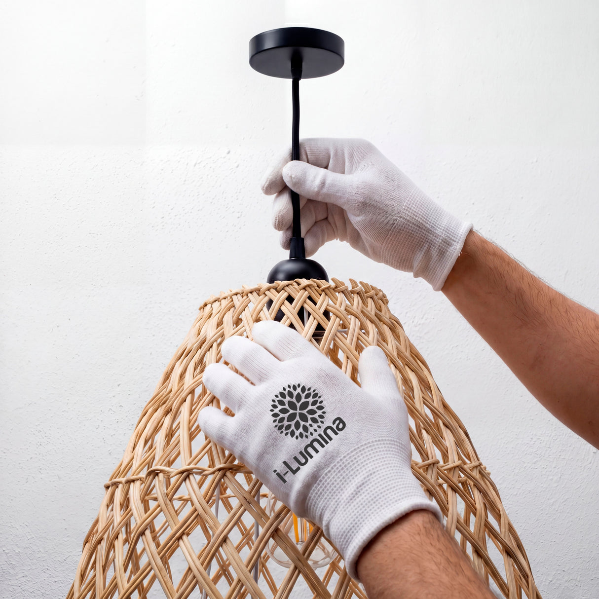 Ajuste de florón negro mate en luminaria de mimbre utilizando guantes de protección técnica.