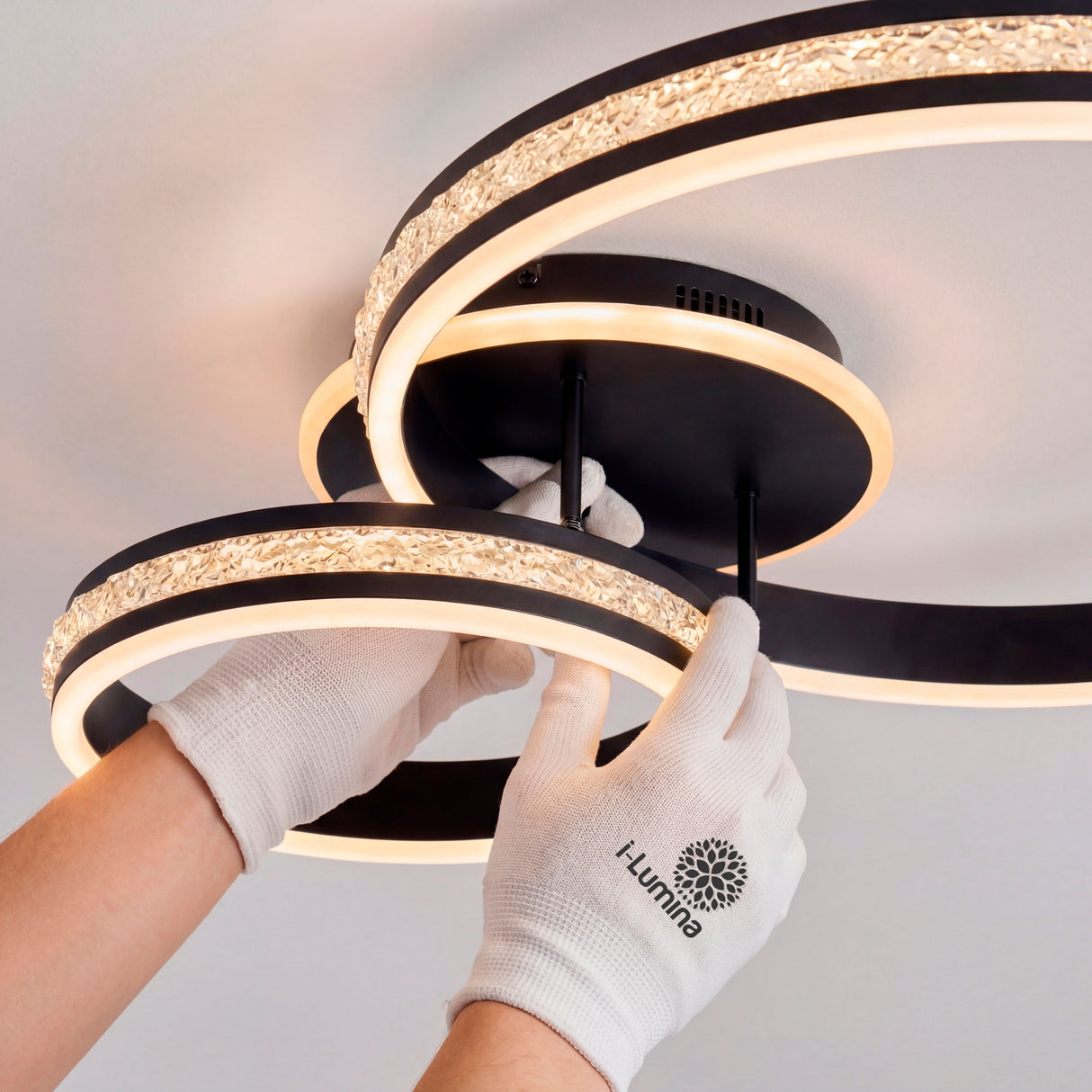 Personal técnico ajustando los aros LED negros con guantes de protección para un acabado limpio.