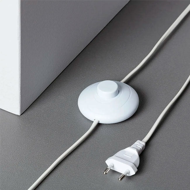 Detalle de cableado con interruptor de pie ergonómico y clavija estándar para domótica residencial.