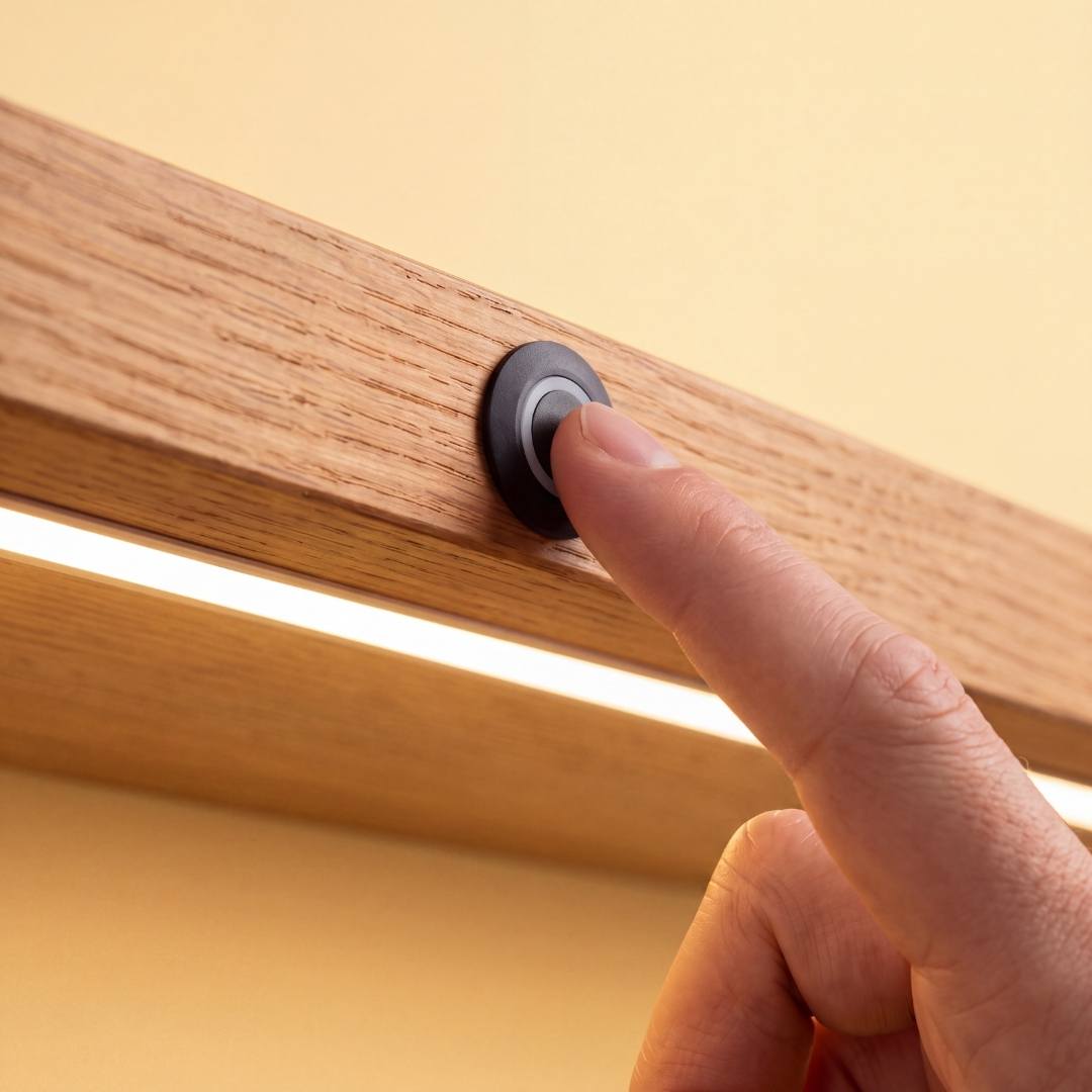 Dedo tocando interruptor sensor táctil que enciende cinta LED en repisa de madera