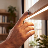 Mano encendiendo cinta LED con un toque en el interruptor sensor táctil