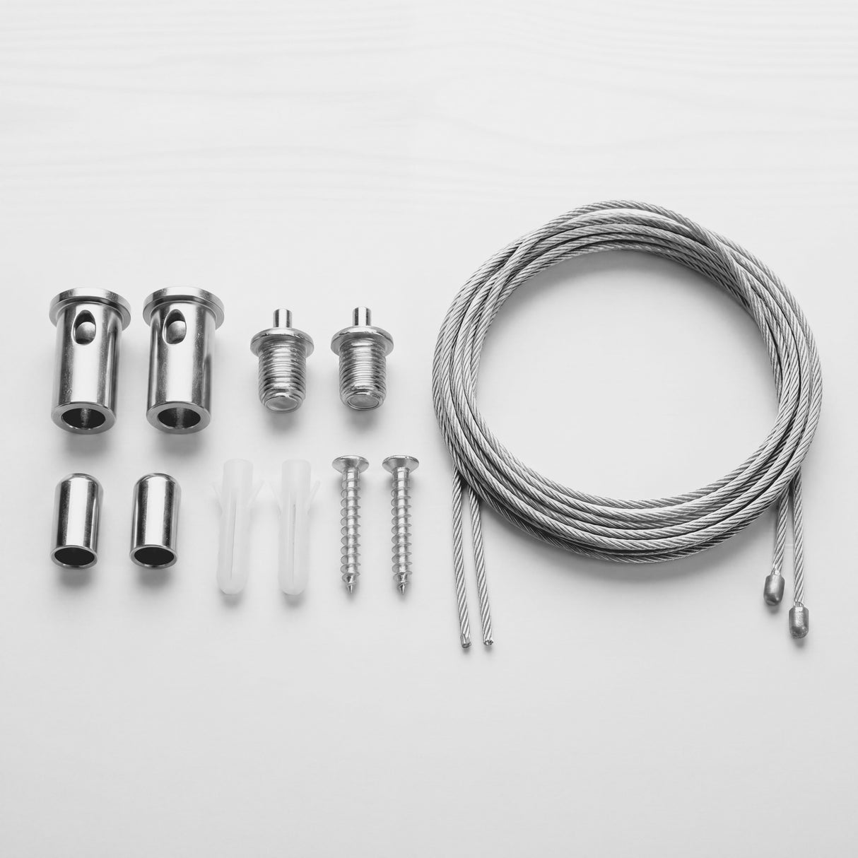 Herrajes metálicos y cables de acero con acabados premium para instalación de luminarias suspendidas.
