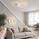 Lámpara LED de doble aro blanco instalada como plafón de techo y aplique de pared en sala moderna.
