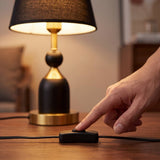 Mano accionando el interruptor de cable de la lámpara de mesa ALBA