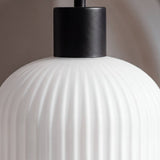 Vista frontal de lámpara colgante negra lineal con tres cabezales de vidrio blanco