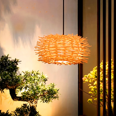 Lámpara de bambú Harumi con luz cálida en ambiente zen junto a un bonsái.
