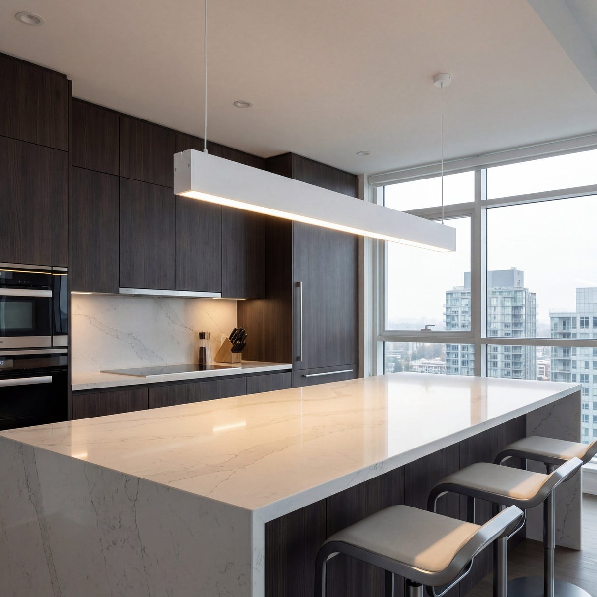 Luminaria blanca sobre isla de cocina minimalista con diseño de líneas puras.