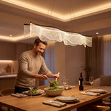 Hombre sirviendo la cena bajo la lámpara colgante LED café encendida