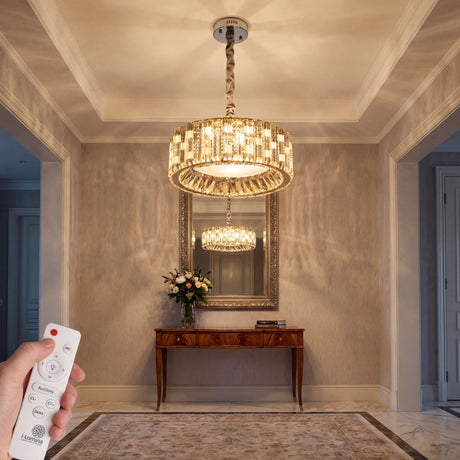 Luminaria circular de cristal en hall elegante con iluminación cálida y control remoto.