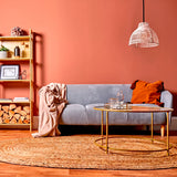 Lámpara Brisa en salón con paredes terracota, aportando un toque natural y artesano.