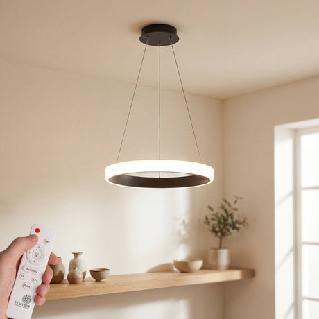 Luminaria circular suspendida en salón moderno con control remoto y luz cálida.