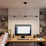 Lampara colgante lineal led negra sobre escritorio de oficina moderna con luz calida.