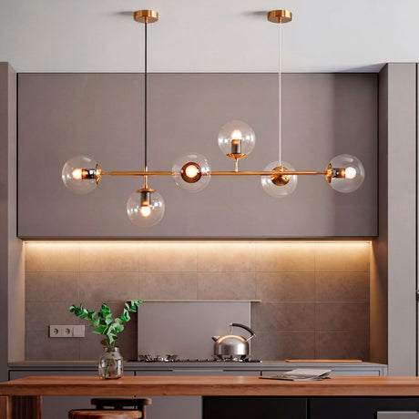 Lámpara colgante Amber Line Gold de diseño horizontal sobre barra de cocina moderna.