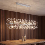 Lámpara colgante MESSIE de cristal K9 cromada encendida sobre una mesa de comedor de madera