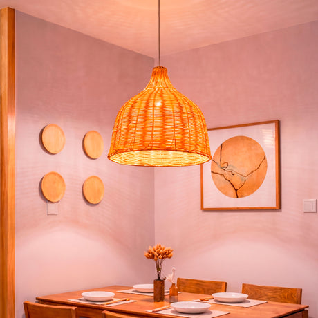 Lámpara de mimbre natural Jasmina Small sobre mesa de comedor rústica de madera.