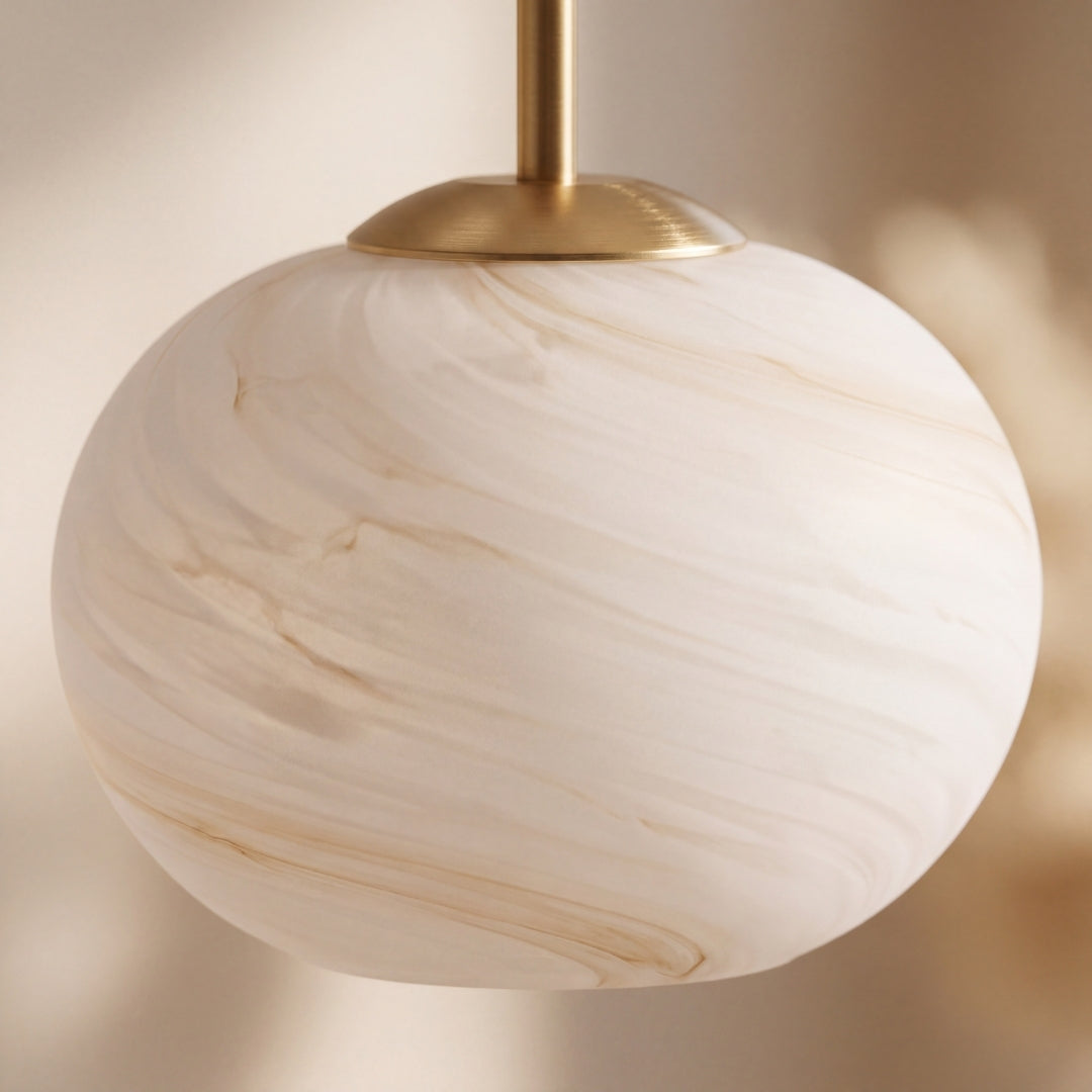 Detalle de globo de vidrio efecto mármol con vetas beige y vástago dorado