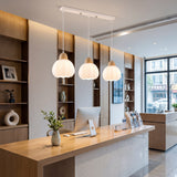 Iluminación para counters de recepción con lámparas lineales de madera y vidrio.