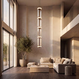 Sala de doble altura iluminada con la lámpara colgante LED ALTEA en luz cálida
