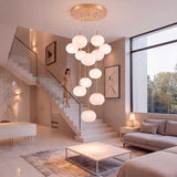 Lámpara colgante OPALA iluminando sala moderna con escalera de doble altura