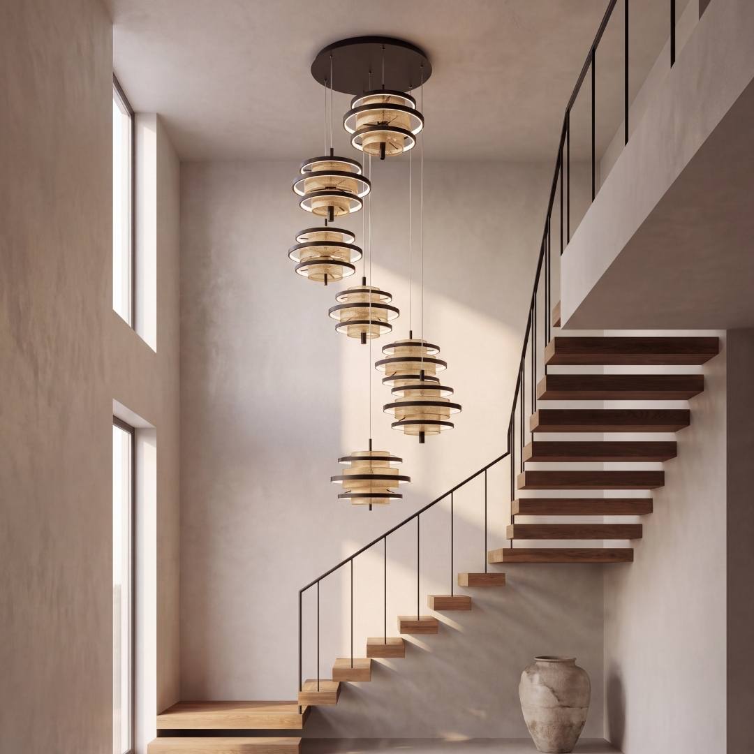 Lámpara colgante LED de 7 luces en cascada junto a escalera de doble altura