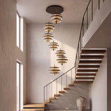 Lámpara colgante LED de 7 luces en cascada junto a escalera de doble altura