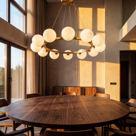 Lampara de techo Collier Gold instalada sobre una mesa de comedor redonda de madera durante el atardecer.