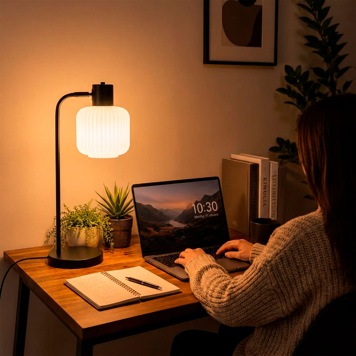 Lámpara de escritorio encendida mientras una persona trabaja en su laptop